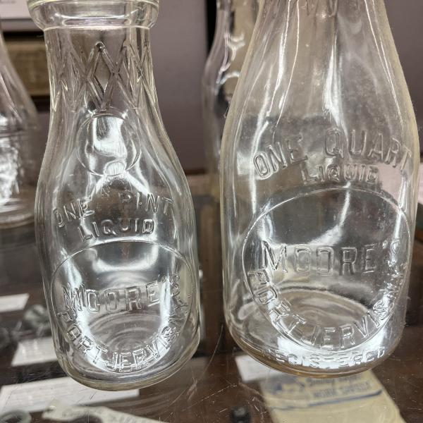 Two milk bottles from Moore's (one quart bottle and one pint bottle)