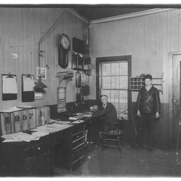 Photograph of interior of Otisville, New York station, with Robert Matthew McDonough at right and father Matthew R. McDonough, agent, at left
