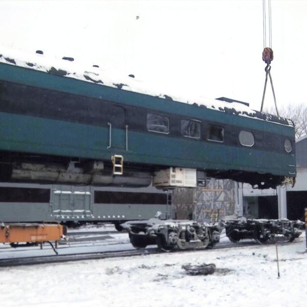 Color photograph of Milwaukee Road passenger car being lifted by crane in Charles City, Iowa, circa 2012