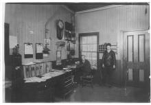 Photograph of interior of Otisville, New York station, with Robert Matthew McDonough at right and father Matthew R. McDonough, agent, at left